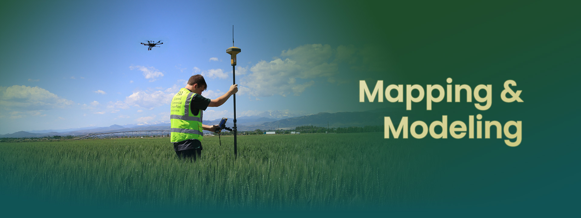 A professional surveying in a field, using equipment for mapping and modeling, with a drone flying above.